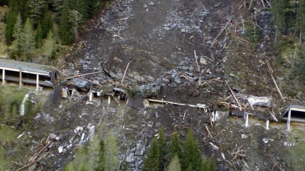 Ein Erdrutsch hat eine Galerie beschädigt, Geröll und Baumstämme liegen auf dem Dach.