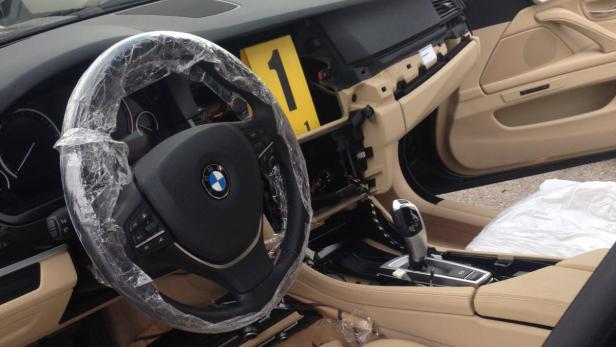 Das Innere eines demontierten BMW mit einem mit Plastikfolie umwickelten Lenkrad.