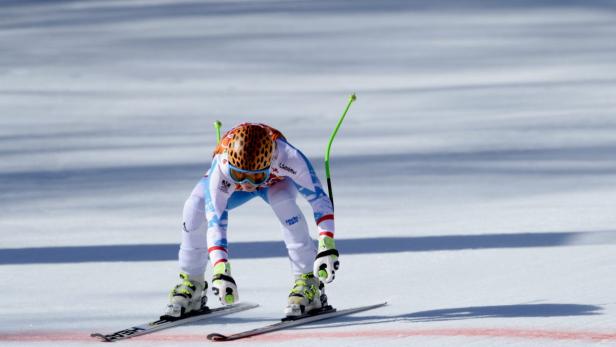 Eine Skirennläuferin in voller Montur steht auf der Piste.