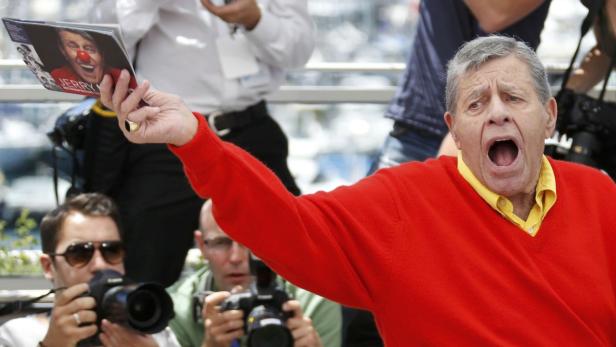 Jerry Lewis hält eine Broschüre mit seinem Konterfei in die Höhe und schreit.