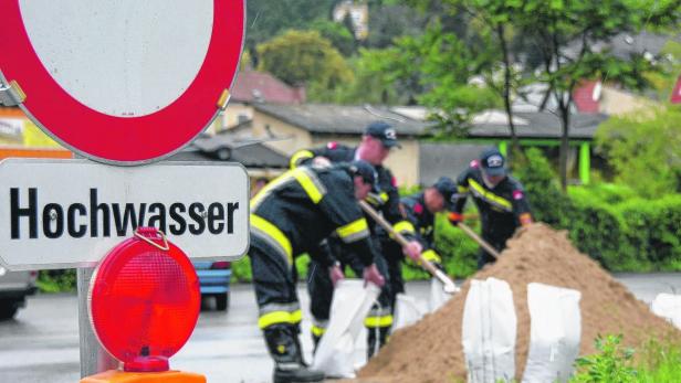 Feuerwehrleute füllen Sandsäcke zum Schutz vor Hochwasser.