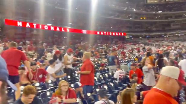 Spectators at the Nationals Park Stadium react after a shooting incident outside