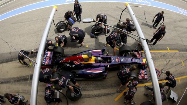 Ein Formel-1-Rennwagen wird von einem Boxenteam betreut.