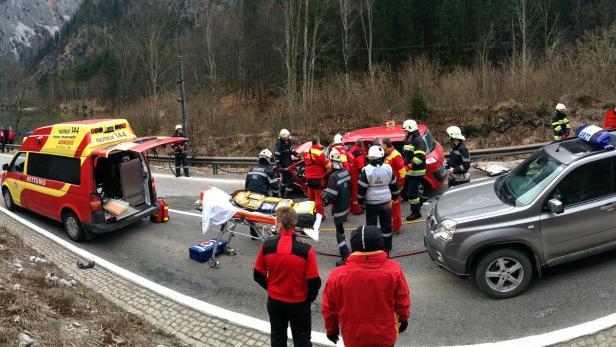 Ein Autounfall mit Rettungskräften und einem Rettungswagen vor einer Bergkulisse.