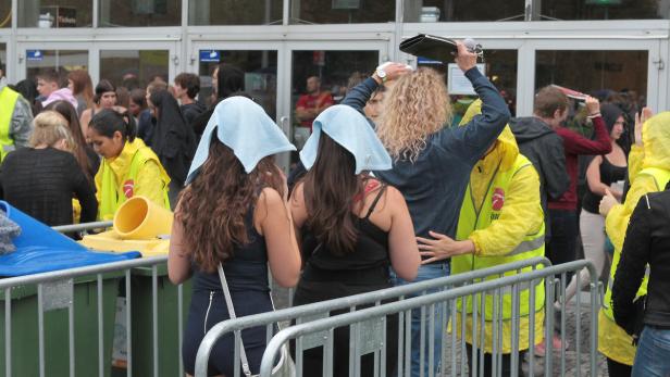 Zwei Frauen mit Handtüchern auf dem Kopf stehen vor einem Veranstaltungsort.