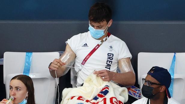 Ein Olympiasieger sitzt auf der Tribüne und strickt