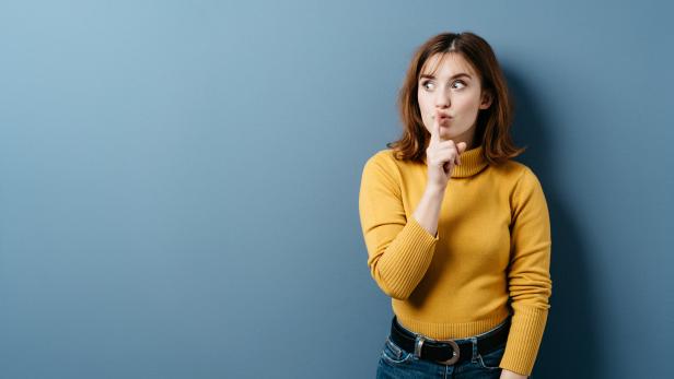 Young woman making a shushing gesture
