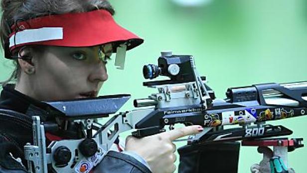 Eine Frau zielt mit einem Luftgewehr auf ein Ziel.