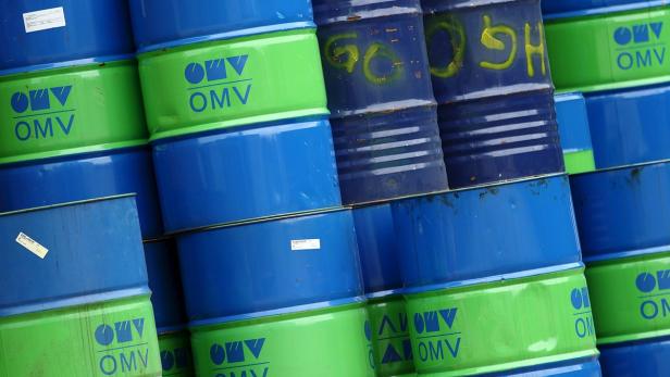 Ein Stapel blauer und grüner Ölfässer mit dem OMV-Logo.