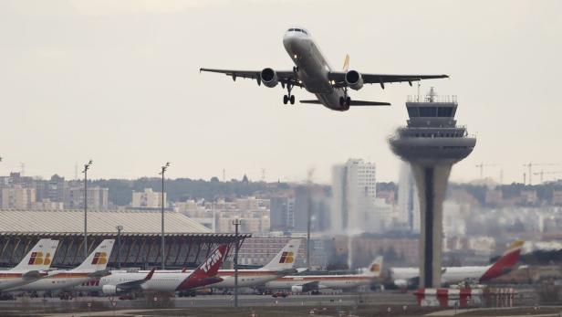 Ein Flugzeug startet am Flughafen, im Hintergrund der Kontrollturm.