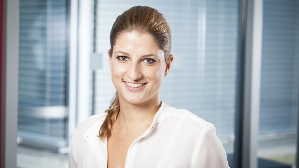 Eine lächelnde Frau in einer Büroumgebung.