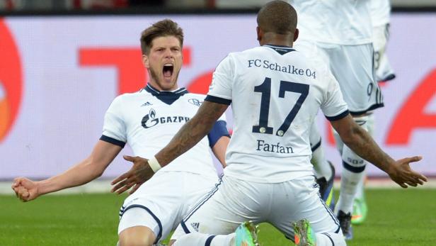Jubelnde Fußballspieler des FC Schalke 04 auf dem Rasen.