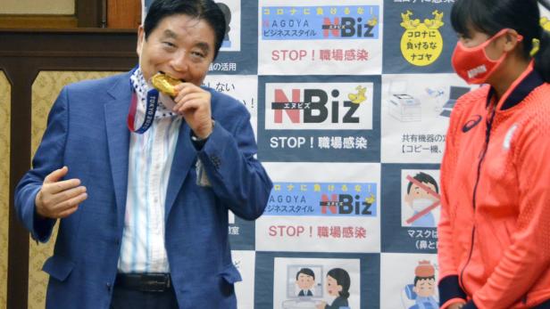 Nagoya city Mayor Takashi Kawamura bites the Tokyo 2020 Olympic Games gold medal of the softball athlete Miu Goto in Nagoya, Japan Bissiger Bürgermeister: Japanerin bekommt neue Olympia-Medaille