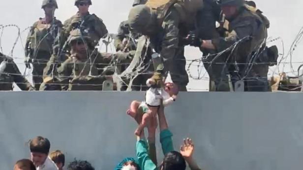 Die Verzweiflung ist groß: Hier wird ein Baby den Soldaten hingehalten