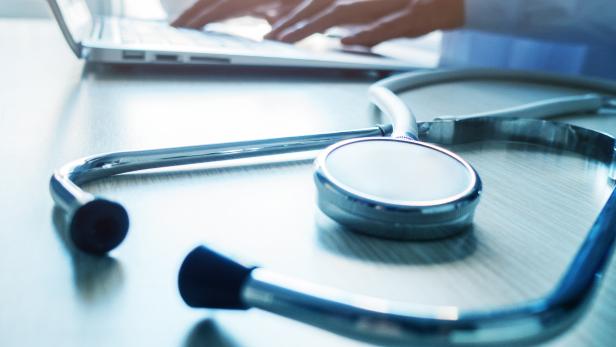 Doctor typing information on the computer in office