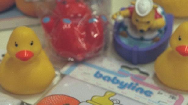 Verschiedene Badespielzeuge, darunter gelbe Enten und ein rotes Nilpferd.