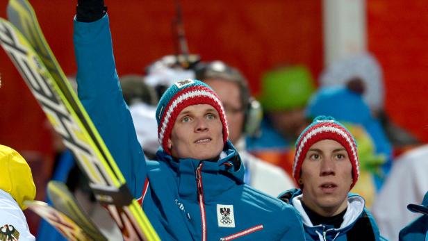 Zwei österreichische Skispringer mit Mützen und Skiern.