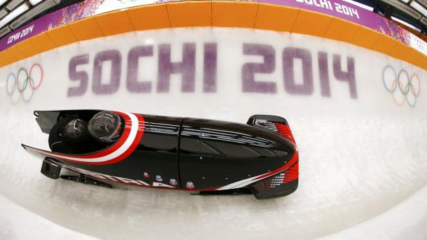 Ein Bob rast auf einer Eisbahn während der Olympischen Winterspiele 2014 in Sotschi.
