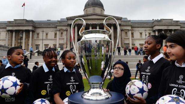 epa03711250 School children look at the UEFA Champions League trophy on diplsay at Trafalgar Square in London, Britain, 22 May 2013. Bayern Munich will play Borussia Dortmund in the Champions League final at Wembley Stadium on 25 May. EPA/ANDY RAIN