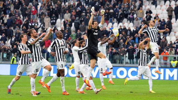 Spieler von Juventus Turin feiern auf dem Rasen.