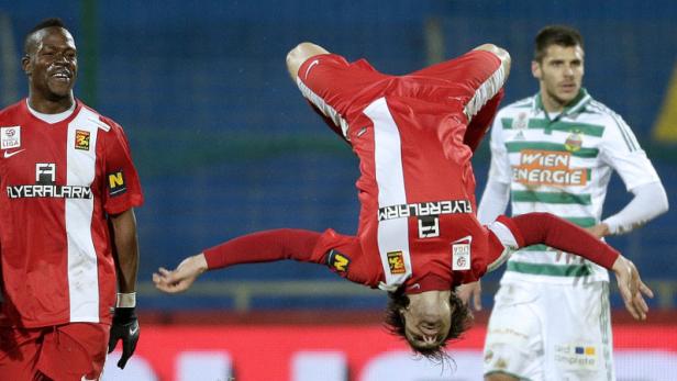 Ein Fußballspieler macht einen Salto auf dem Spielfeld.