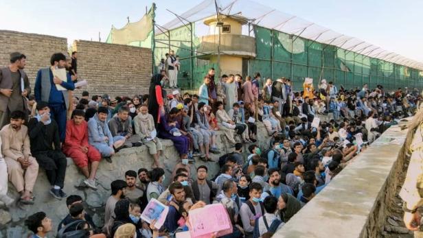 FILE PHOTO: Crowds of people wait outside the airport in Kabul