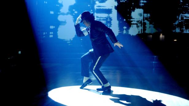 Michael Jackson tanzt in einem blauen Scheinwerferlicht.