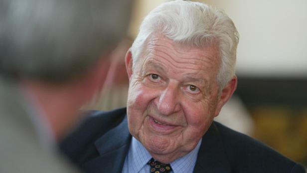 Ein älterer Mann mit grauem Haar lächelt in die Kamera.