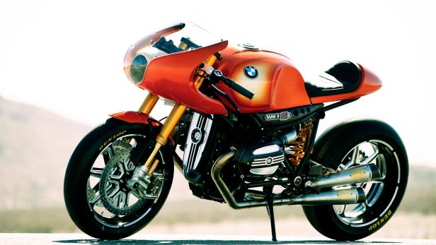 Ein orangefarbenes BMW R nineT Motorrad im Café-Racer-Stil steht auf einer Straße.