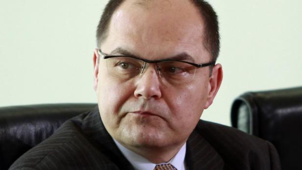 Ein Mann mit Brille und Anzug schaut aufmerksam zur Seite.