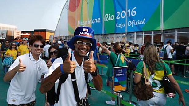Besucher geben vor dem Megastore Rio 2016 die Daumen hoch.