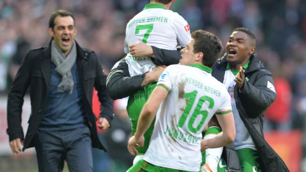 Spieler von Werder Bremen feiern mit ihrem Trainer einen Sieg.
