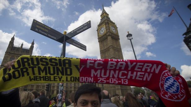 epa03716148 A man poses with a scarf marking the final in front of Big Ben, London, Britain, 25 May 2013. German clubs Borussia Dortmund and Bayern Munich play the UEFA Champions League final on May 25th at the Wembley stadium in London. EPA/BOGDAN MARAN