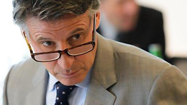 Ein Mann mit Brille und Anzug blickt aufmerksam zur Seite.