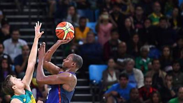 Ein Basketballspieler wirft den Ball, während ein Gegenspieler ihn zu blocken versucht.