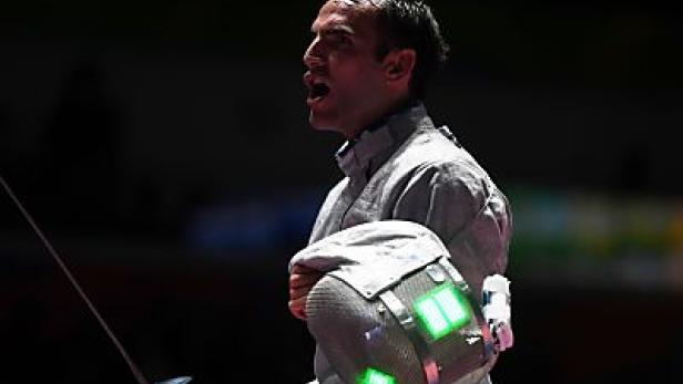 Ein Fechter hält seine Maske und ein Schwert in der Hand und schreit.