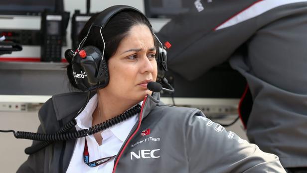 Eine Frau mit Headset und Jacke des Sauber F1 Teams bei der Arbeit.