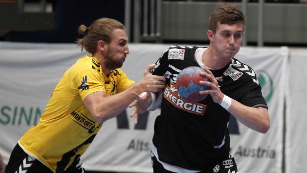 Zwei Handballspieler kämpfen um den Ball während eines Spiels.