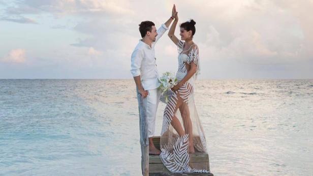 Topmodel heiratet im durchsichtigen Kleid am Strand