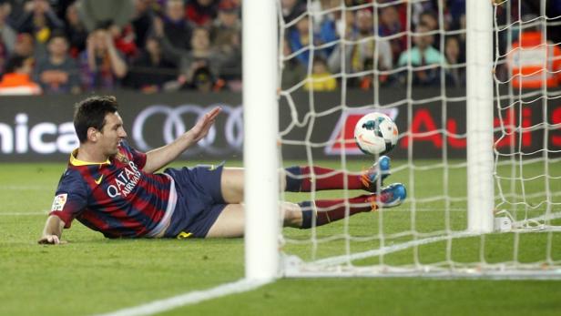 Lionel Messi erzielt ein Tor für Barcelona, während er auf dem Rasen liegt.