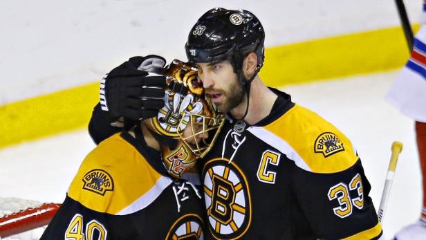 Boston Bruins Zdeno Chara (R) embraces goalie Tuukka Rask after they defeated the New York Rangers during Game 5 of their NHL Eastern Conference semi final hockey playoff game in Boston, Massachusetts May 25, 2013. REUTERS/Brian Snyder (UNITED STATES - Tags: SPORT ICE HOCKEY)