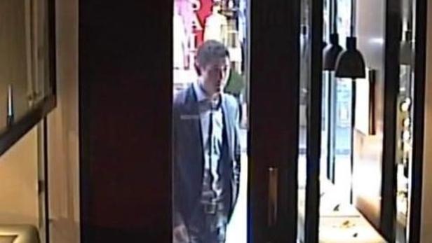 Ein Mann in Anzug und Krawatte steht in einer Türöffnung.