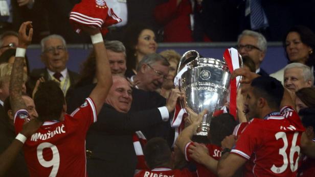 Spieler des FC Bayern München feiern mit dem gewonnenen Europapokal.