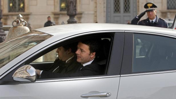 Matteo Renzi fährt in einem Auto, während ein Polizist salutiert.