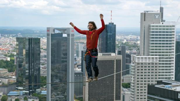 epa03716420 The professional slackliner Reinhard Kleindl from Austria walks on a 185 m high rope between two towers of the &#039;Tower 185&#039; during the skyscraper festival in Frankfurt/Main, Germany, 25 May 2013. Several hundred thousand visitors are expected to come to the two-day spectacle. Highlights are spectacular performances in the air and numerous concerts. EPA/NICOLAS ARMER