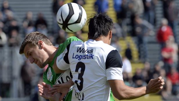 Zwei Fußballspieler kämpfen um einen Ball in der Luft.