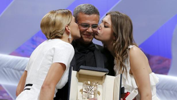Actresses Lea Seydoux (L) and Adele Exarchopoulos (R) kiss director Abdellatif Kechiche (C) as they pose on stage after receiving the Palme d&#039;Or award for the film &quot;La Vie D&#039;Adele&quot; during the closing ceremony of the 66th Cannes Film Festival in Cannes May 26, 2013. REUTERS/Yves Herman (FRANCE - Tags: ENTERTAINMENT TPX IMAGES OF THE DAY)
