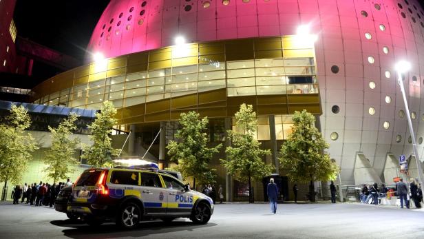 Ein schwedischer Polizeiwagen vor dem Globen in Stockholm bei Nacht.