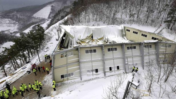 Ein beschädigtes Gebäude mit eingestürztem Dach in einer verschneiten Landschaft.