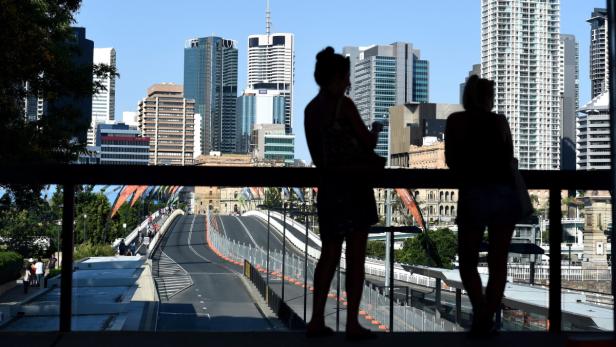 Zwei Frauen betrachten die Skyline von Brisbane, Australien, von einer Brücke aus.